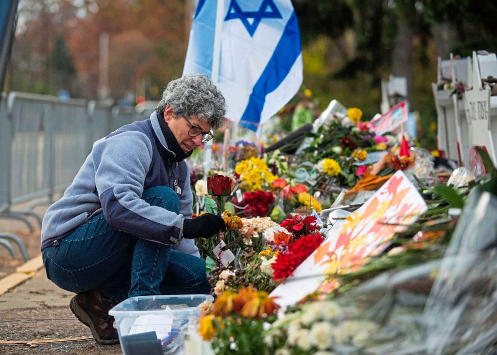 Laurie Eisenberg, a Tree of Life synagogue congregant and board member, helps deconstruct the memorial in front of the synagogue on Nov. 14, 2018.