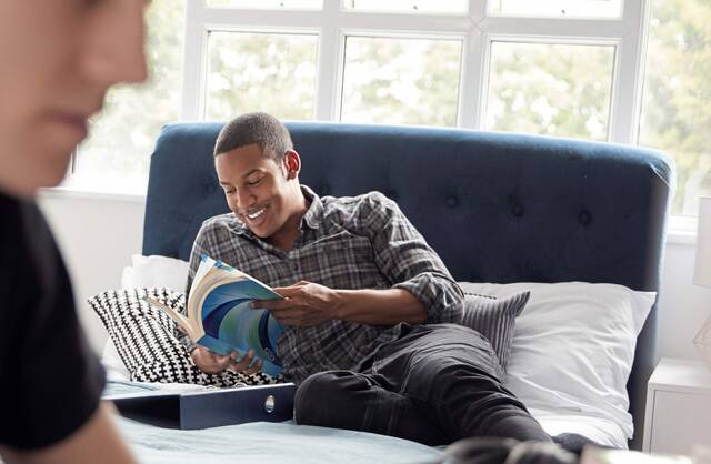 4223584_web1_Tuition-Reduction-Ad-Image_two-male-college-students-in-shared-house-bedroom--B3KLT8P