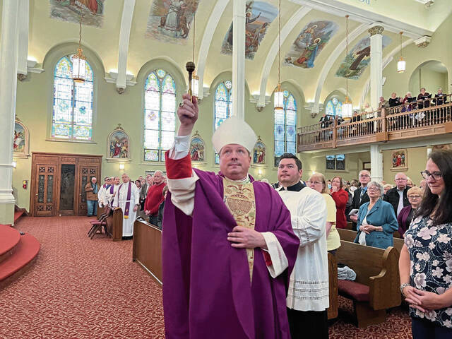 5656501_web1_Bishop-Larry-Kulick-blesses-a-reporter