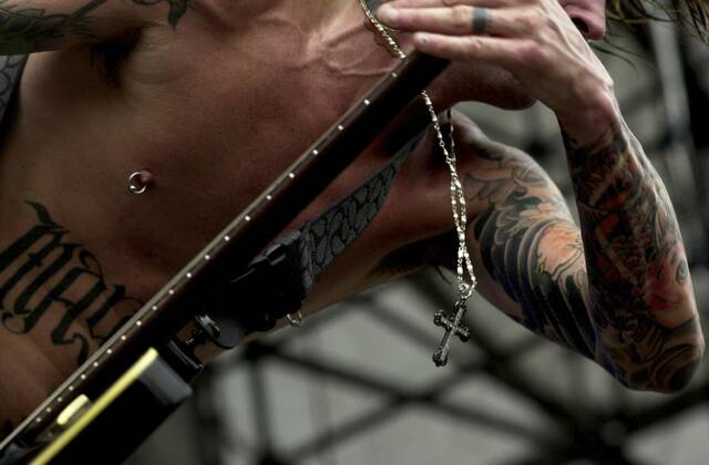 
			
				                                Rocker Tommy Lee jams out while performing in front of thousands of fans at the Rolling Rock Town Fair at the Westmoreland Fairgrounds on July 27, 2002.

			
		