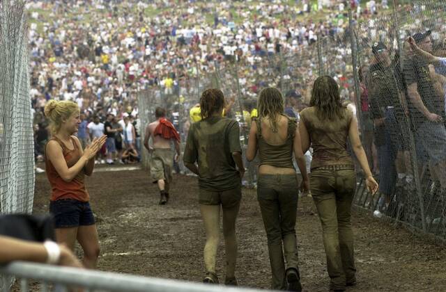 
			
				                                After being ejected from the mosh pit for crowd surfing, Katie Hoffer of Latrobe cheers as three muddy girls emerge unscathed at the Rolling Rock Town Fair on July 27, 2002. 

			
		