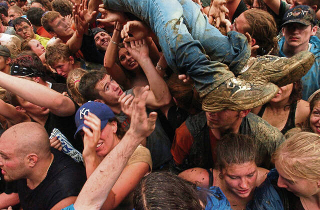 
			
				                                People hold up a crowd surfer during the Rolling Rock Town Fair at the Westmoreland County Fairgrounds on July 31, 2004.

			
		