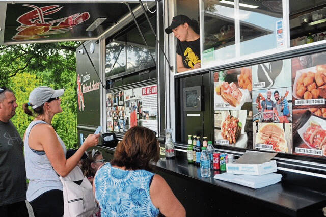 9113877_web1_Michelle-Bullow-takes-orders-for--Cousins-Maine-Lobster-truck-during-a-Northland-Library-50th-anniversary--celebration-Sunday-Aug.-12-2018.--Louis-Raggiunti--l--For-the--Tribune-Review---Copy