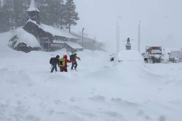 Members of a rescue team trudge through snow Tuesday in Soda Springs, Calif. (Nevada County Sheriffs Office via AP)