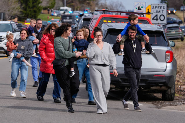 
			
				                                Law enforcement escort families with children away from the Temple Israel synagogue Thursday in West Bloomfield Township, Mich. (AP)

			
		