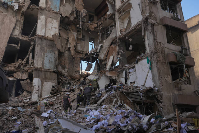 Lebanese civil defense workers search for victims Thursday in the rubble of a building destroyed in an Israeli airstrike a day earlier in central Beirut, Lebanon. (AP)