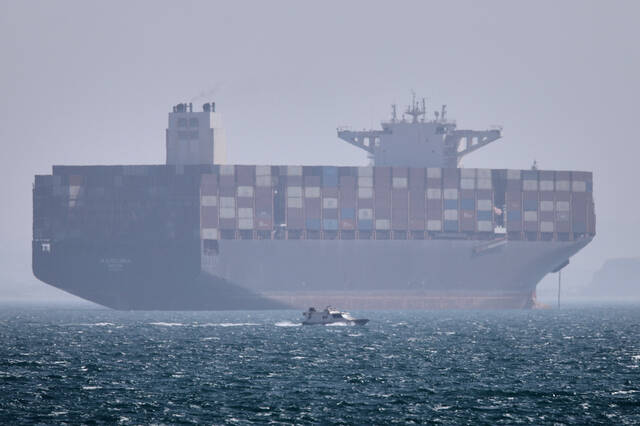 
			
				                                A container ship sits at anchor as a small motorboat passes in the foreground in the Strait of Hormuz off Bandar Abbas, Iran. (AP)

			
		