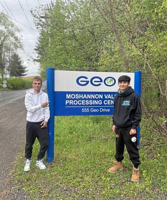 Carnegie resident Luis Gilberto Loja Mayancela, 24, stands next to a sign for U.S. Immigration and Customs Enforcement’s Moshannon Valley Processing Center in Clearfield County. Mayancela was released on bond Friday, May 8. At left is Ian James, Mayancela’s friend and sponsor during his immigration proceedings. (Courtesy of Ian James)